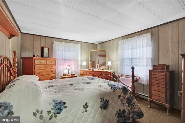 a bedroom with a bed and dresser with mirror