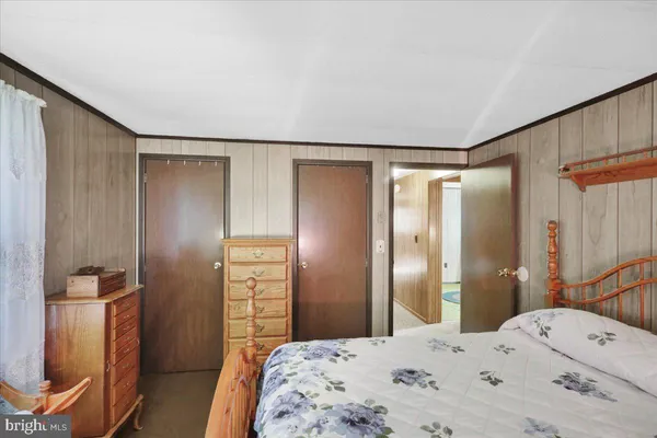 a bedroom with a bed and a refrigerator