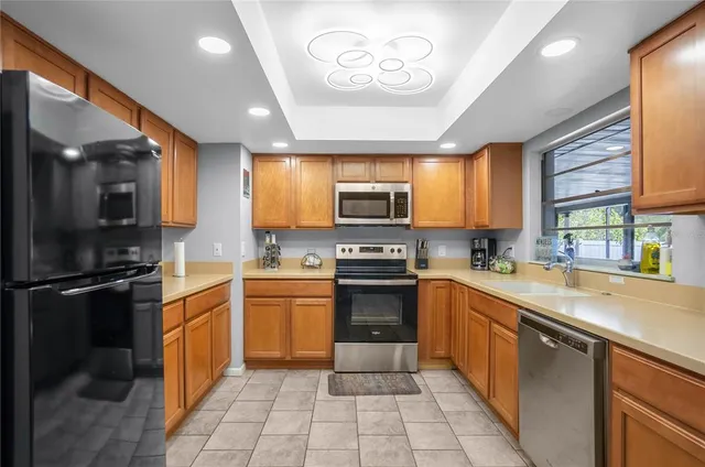 a kitchen with a sink a stove top oven and cabinets