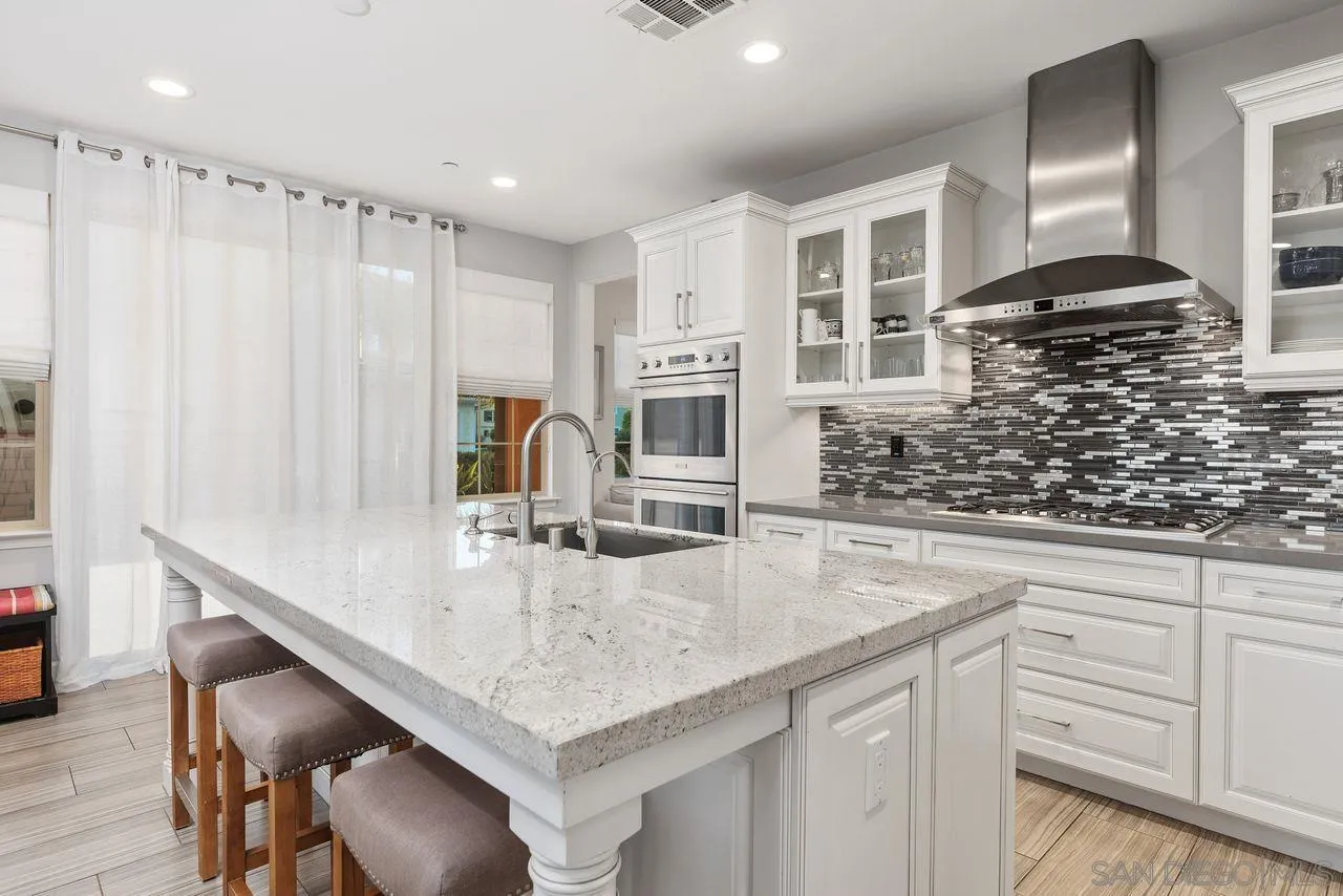 13509 Cielo Ranch Road San Diego, CA 92130 - Photo 26 of 54 a kitchen with stainless steel appliances granite countertop a sink and a white cabinets