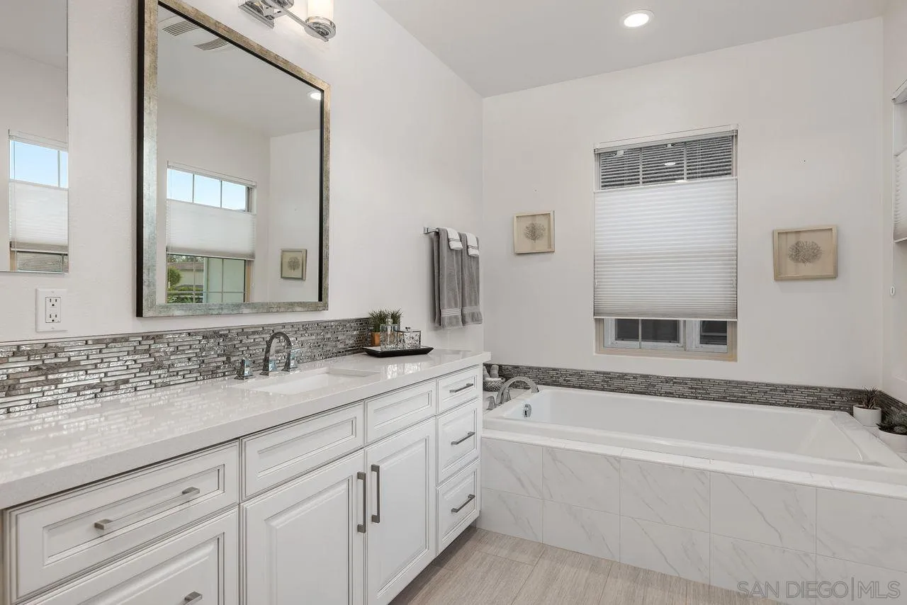 13509 Cielo Ranch Road San Diego, CA 92130 - Photo 32 of 54 a bathroom with a bathtub a double vanity sink and mirror