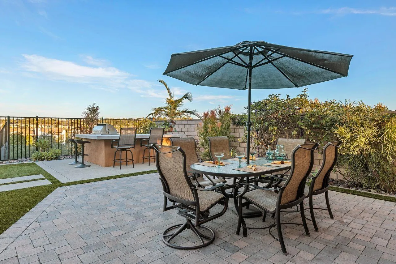 13509 Cielo Ranch Road San Diego, CA 92130 - Photo 40 of 54 a patio with a table and chairs under an umbrella