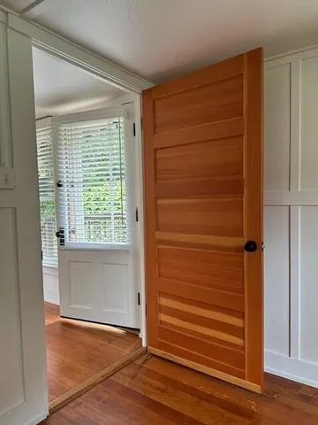 an empty room with wooden floor and windows