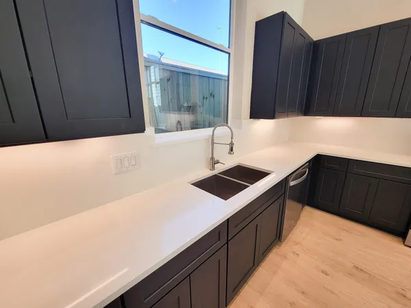 a kitchen with a sink and a stove top oven