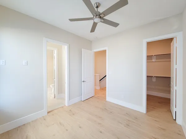 an empty room with closet and a ceiling fan