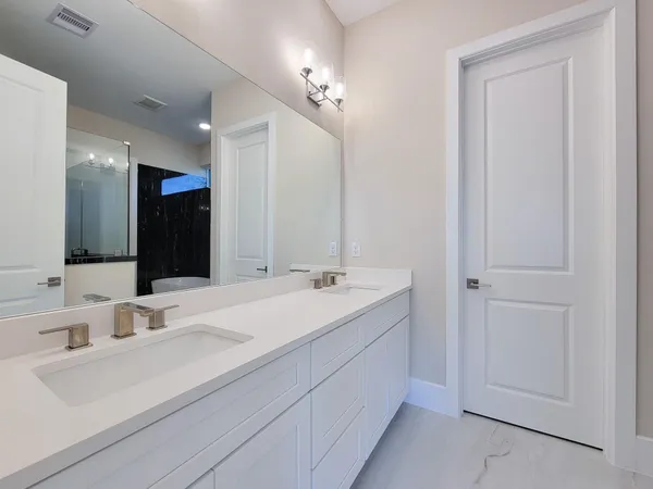 a bathroom with a double vanity sink mirror and