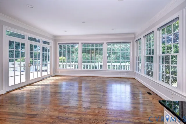 a view of empty room with wooden floor and floor to ceiling window