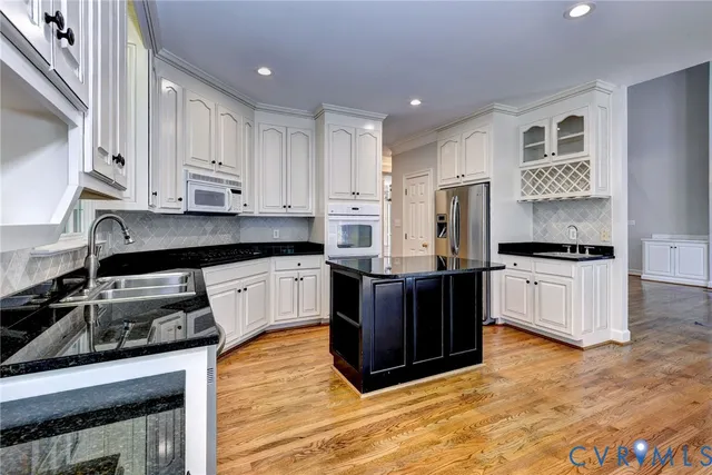 a kitchen with stainless steel appliances granite countertop a stove a sink and a refrigerator