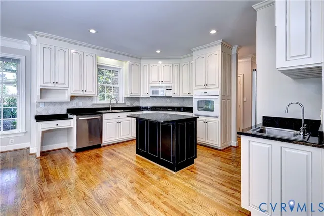 a kitchen with stainless steel appliances granite countertop a stove a sink dishwasher and a refrigerator