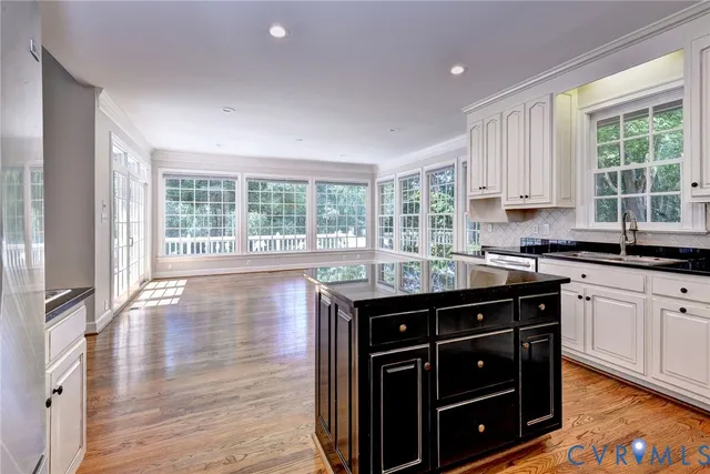 a kitchen with granite countertop a stove a sink and wooden cabinets
