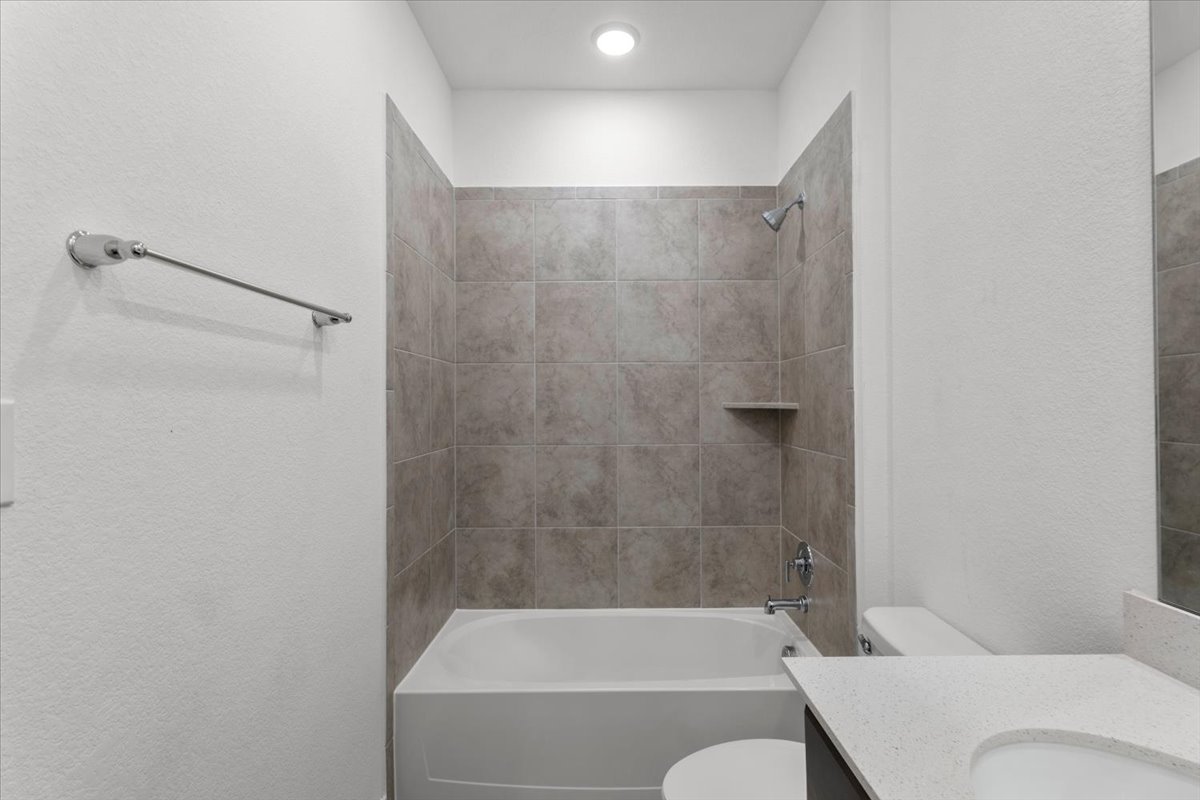 500 Stinchcomb Road Hutto, TX 78634 - Photo 28 of 37 A well-lit bathroom featuring a clean tub and tiled shower enclosure.