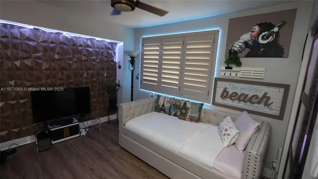 a view of a backyard with wooden fence and a large tree