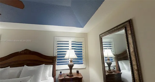 a bedroom with a bed and a flat tv screen on wall