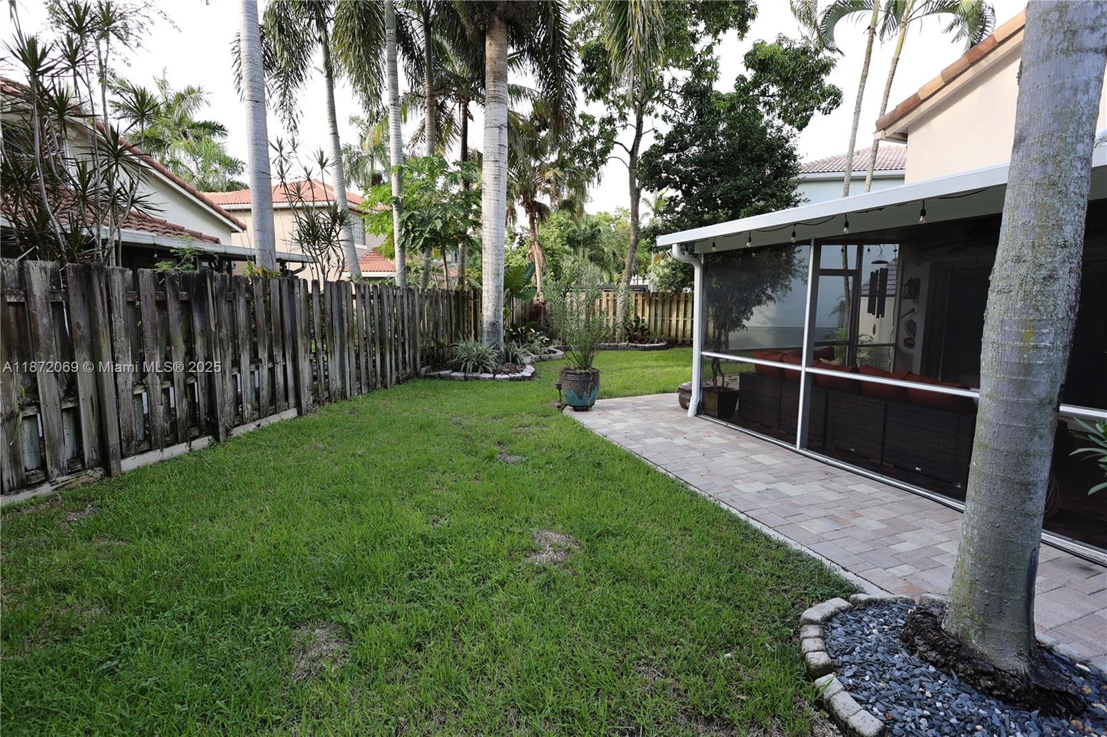 11251 Reveille Road Cooper City, FL 33026 - Photo 61 of 82 a view of a backyard with wooden fence and a large tree