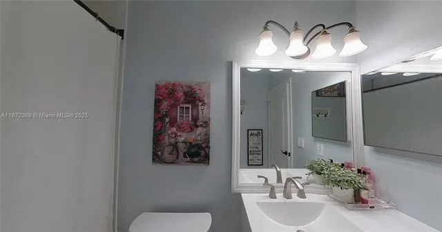 a view of storage and utility room with wooden floor and fan