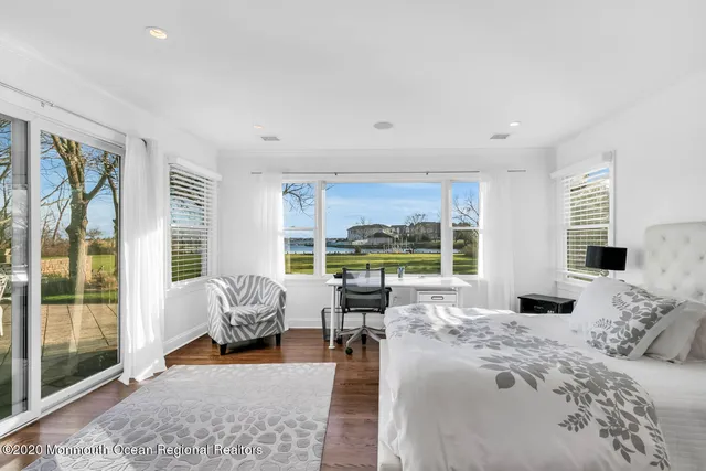 a bedroom with furniture and large windows