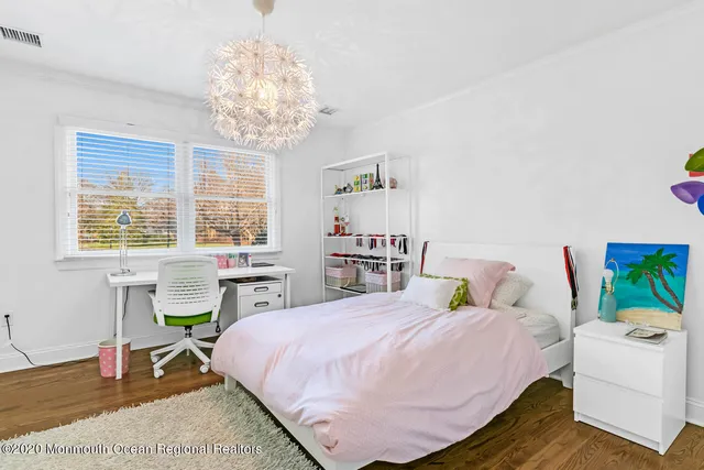 a bedroom with a bed and a table chair