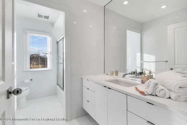 a bathroom with double vanity and a tub