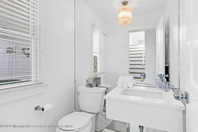 a bathroom with a sink a toilet and a window