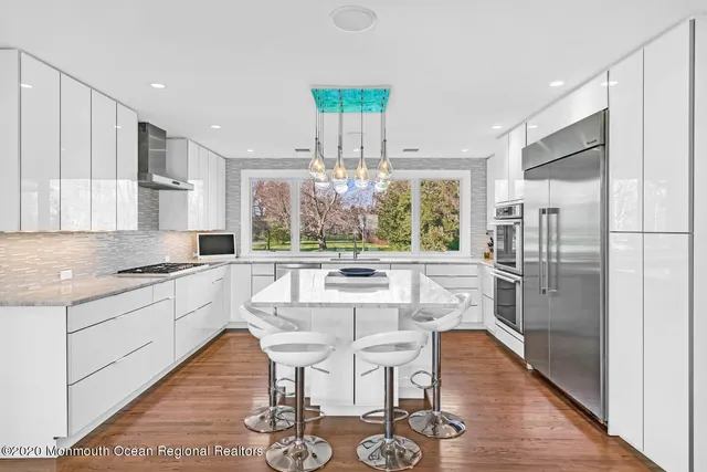 a kitchen with a dining table chairs refrigerator and cabinets