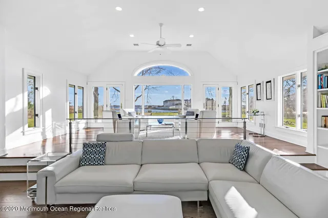 a living room with furniture kitchen view and a large window