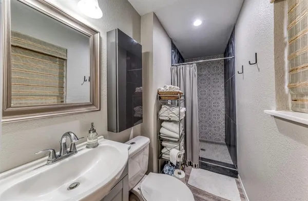 a bathroom with a sink toilet and shower