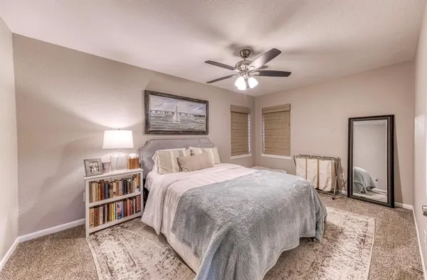 a bedroom with a large bed and a chandelier