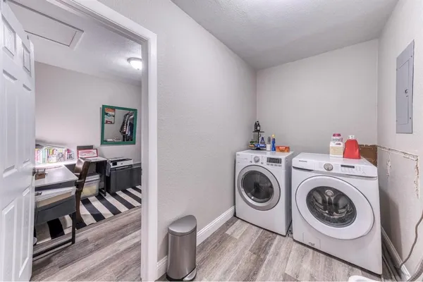 a utility room with dryer washer and a view of living room