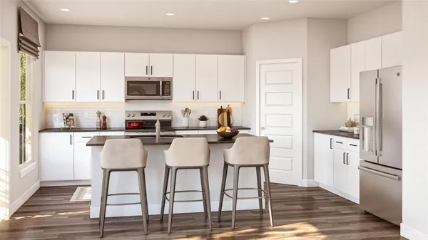 a kitchen with stainless steel appliances a refrigerator stove microwave and cabinets