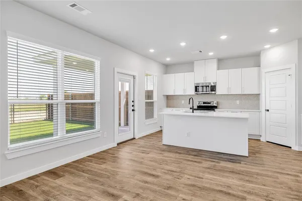 a kitchen with stainless steel appliances a refrigerator and a stove top oven