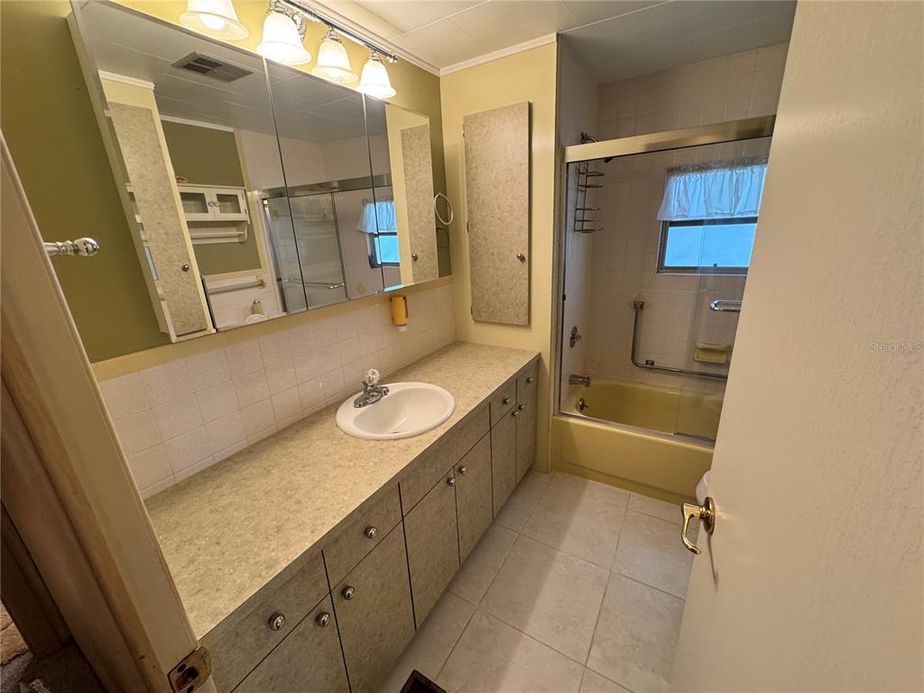 2331 Belleair Road, Unit LOT 237 Clearwater, FL 33764 - Photo 19 of 33 a bathroom with a granite countertop sink mirror vanity and bathtub