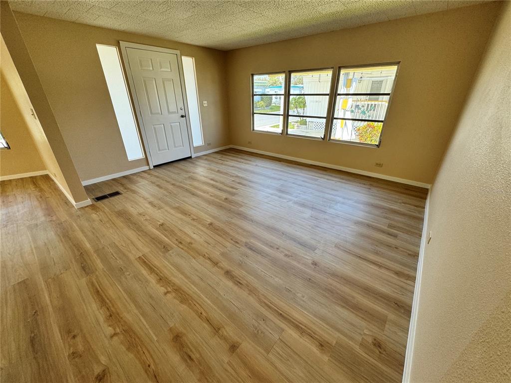 2331 Belleair Road, Unit LOT 237 Clearwater, FL 33764 - Photo 7 of 33 a view of an empty room with wooden floor and a window