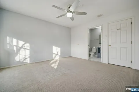 a view of empty room with window and ceiling fan