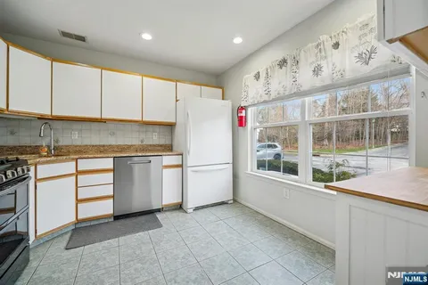 a kitchen with granite countertop a white stove top oven and cabinets