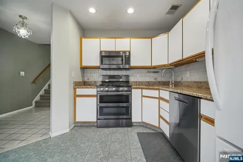 a kitchen with stainless steel appliances granite countertop a stove and a refrigerator