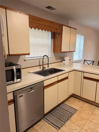 a kitchen with a sink cabinets and a window
