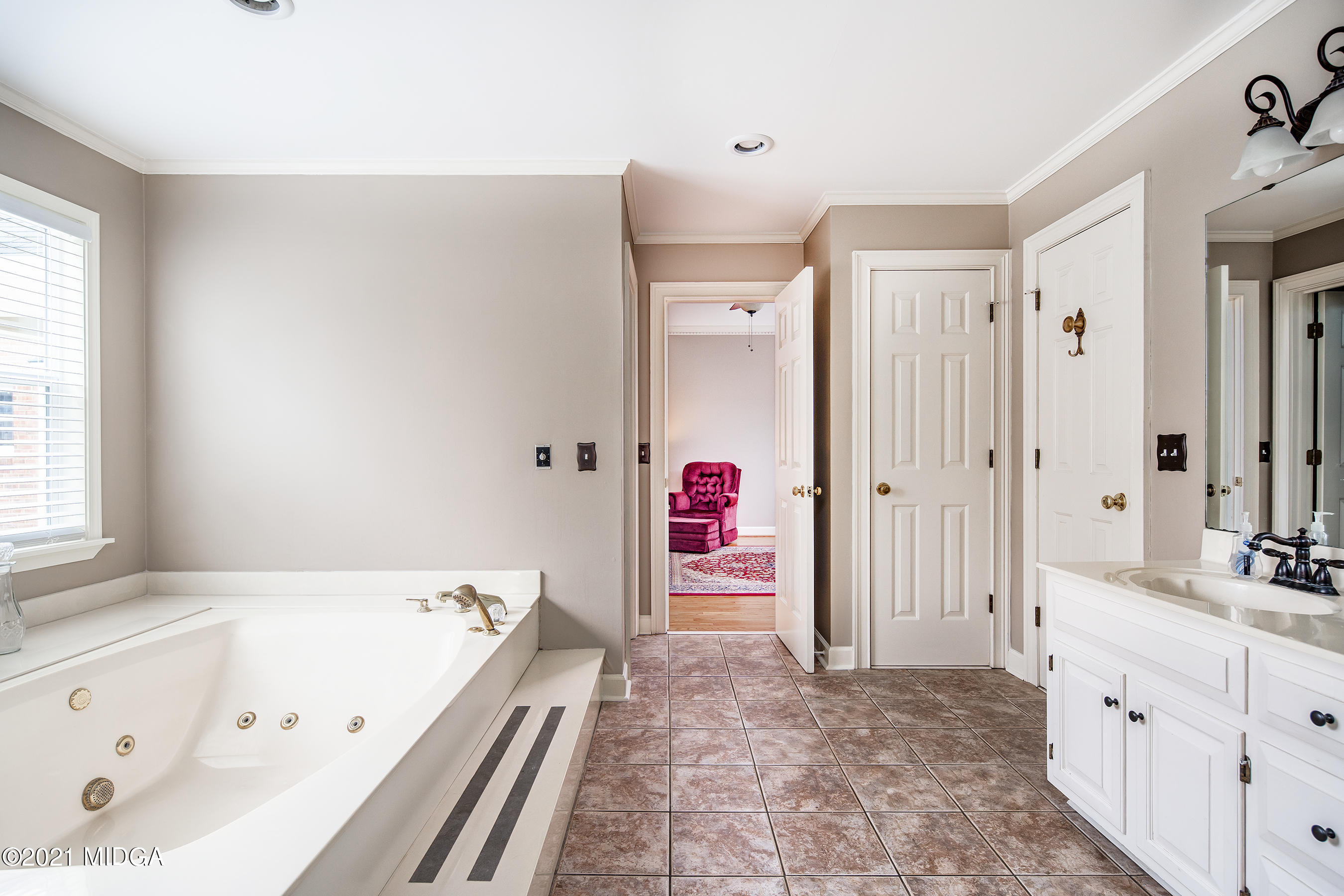 155 Castlegate Road Macon, GA 31210 - Photo 11 of 34 a bathroom with a tub a sink and a large mirror