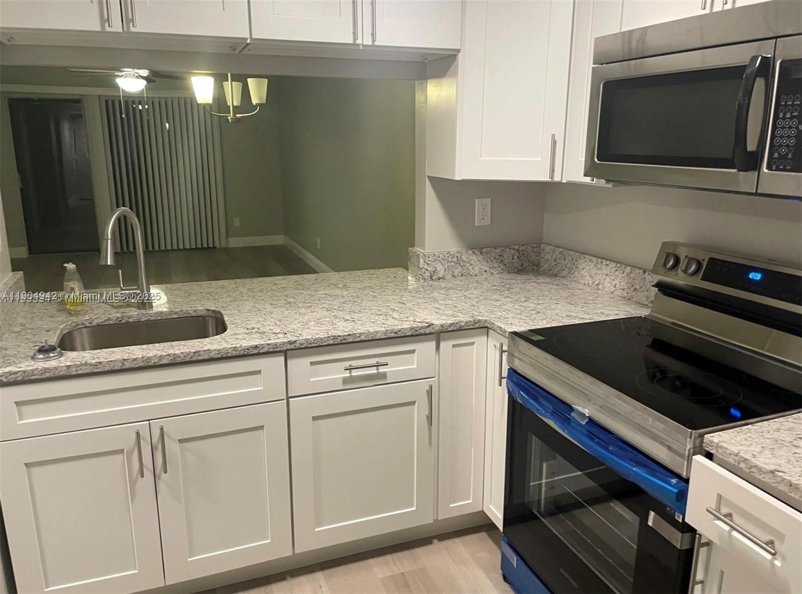 3252 Foxcroft Road, Unit 314 Miramar, FL 33025 - Photo 2 of 9 a kitchen with stainless steel appliances white cabinets and a stove
