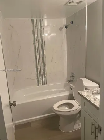 a white toilet sitting next to a bathroom sink