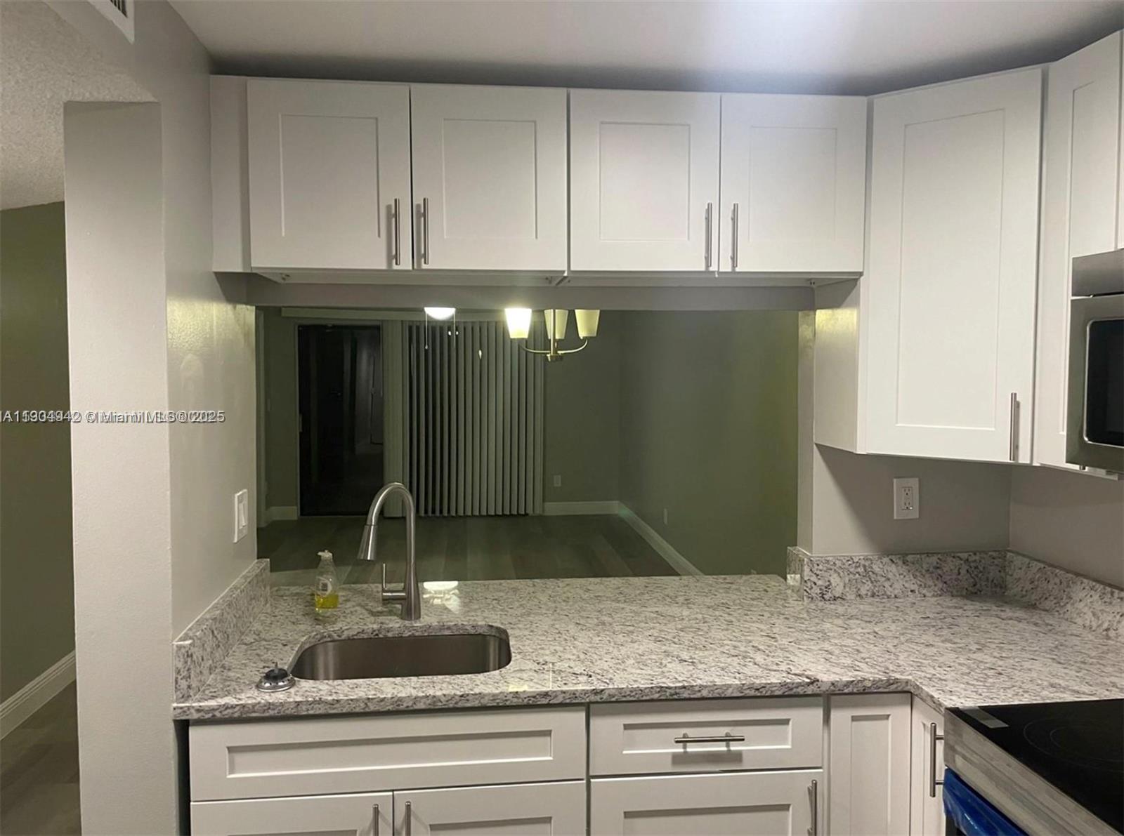 3252 Foxcroft Road, Unit 314 Miramar, FL 33025 - Photo 9 of 9 a kitchen with granite countertop a sink and cabinets