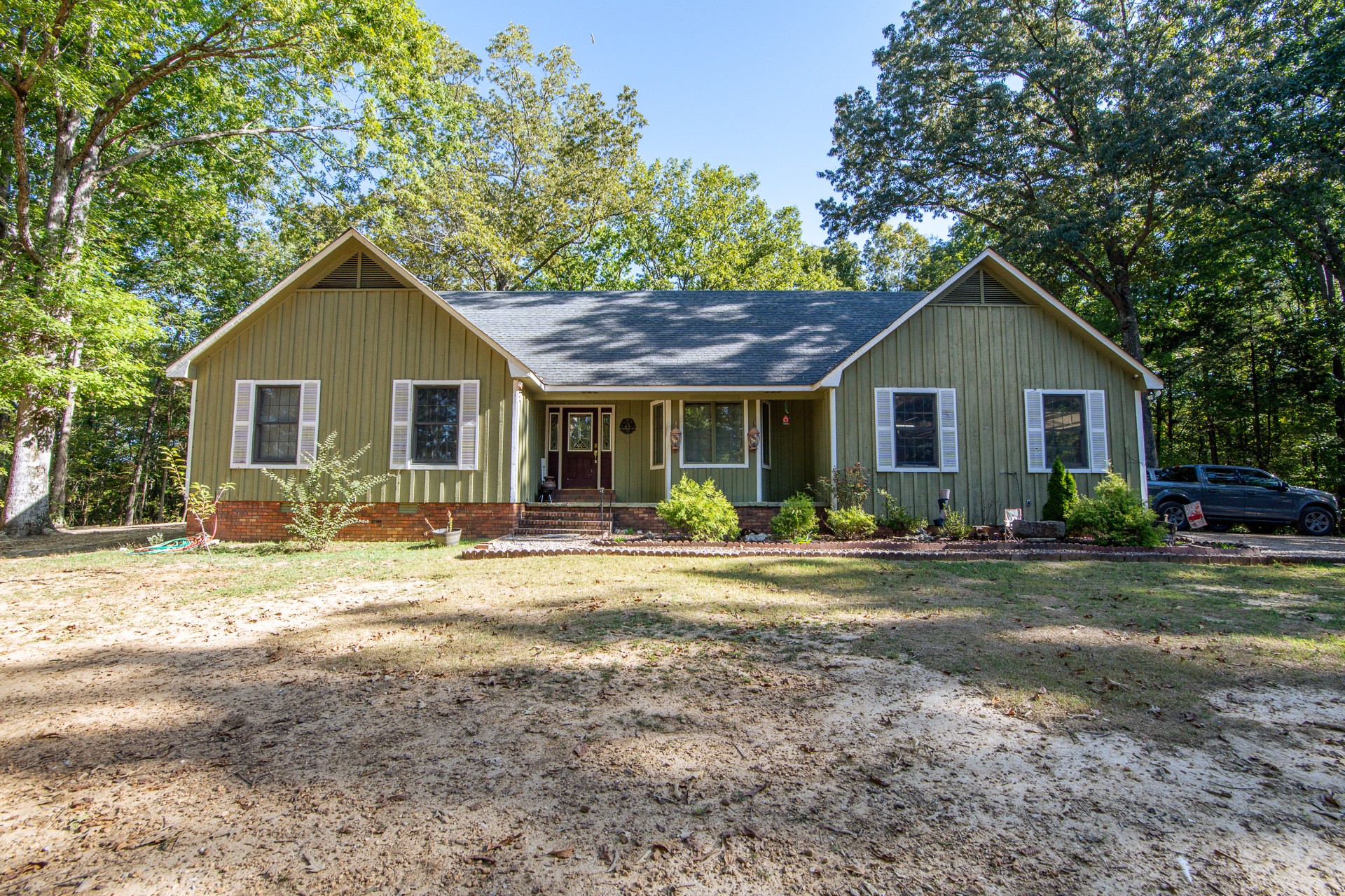 a front view of a house with a garden and trees