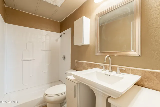 a bathroom with a sink toilet and shower