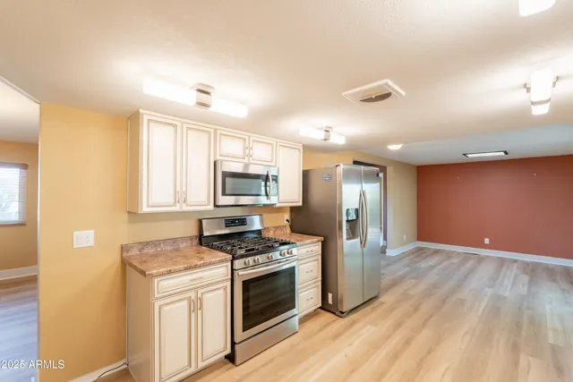 a kitchen with stainless steel appliances a stove a sink and a refrigerator