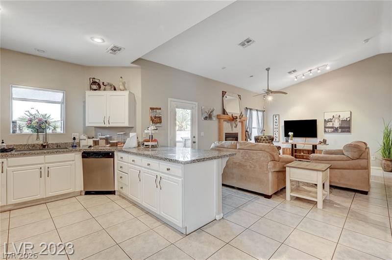 987 Cutter Street Henderson, NV 89011 - Photo 3 of 17 An inviting open-concept layout connects a well-appointed kitchen to a comfortable living area, perfect for daily life.