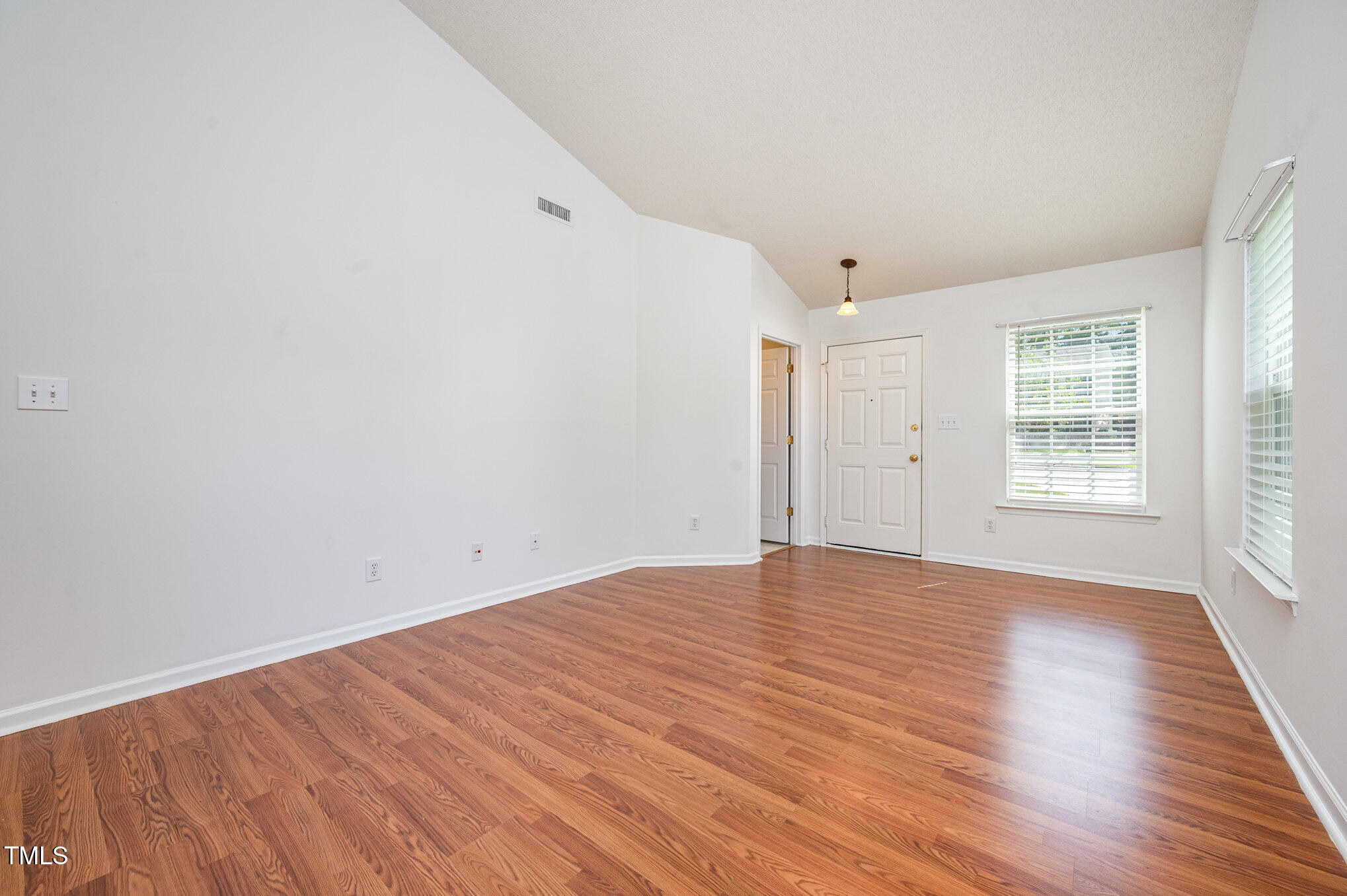 102 Checker Court Apex, NC 27502 - Photo 4 of 15 an empty room with wooden floor and windows