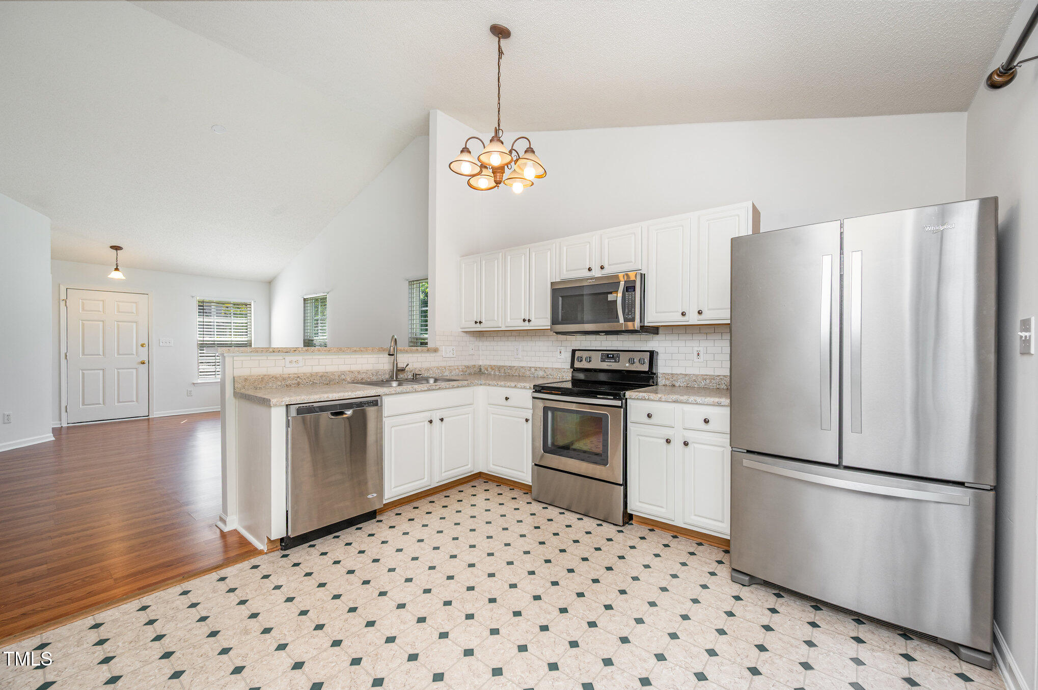 102 Checker Court Apex, NC 27502 - Photo 6 of 15 a kitchen with a refrigerator a sink dishwasher a stove and white cabinets