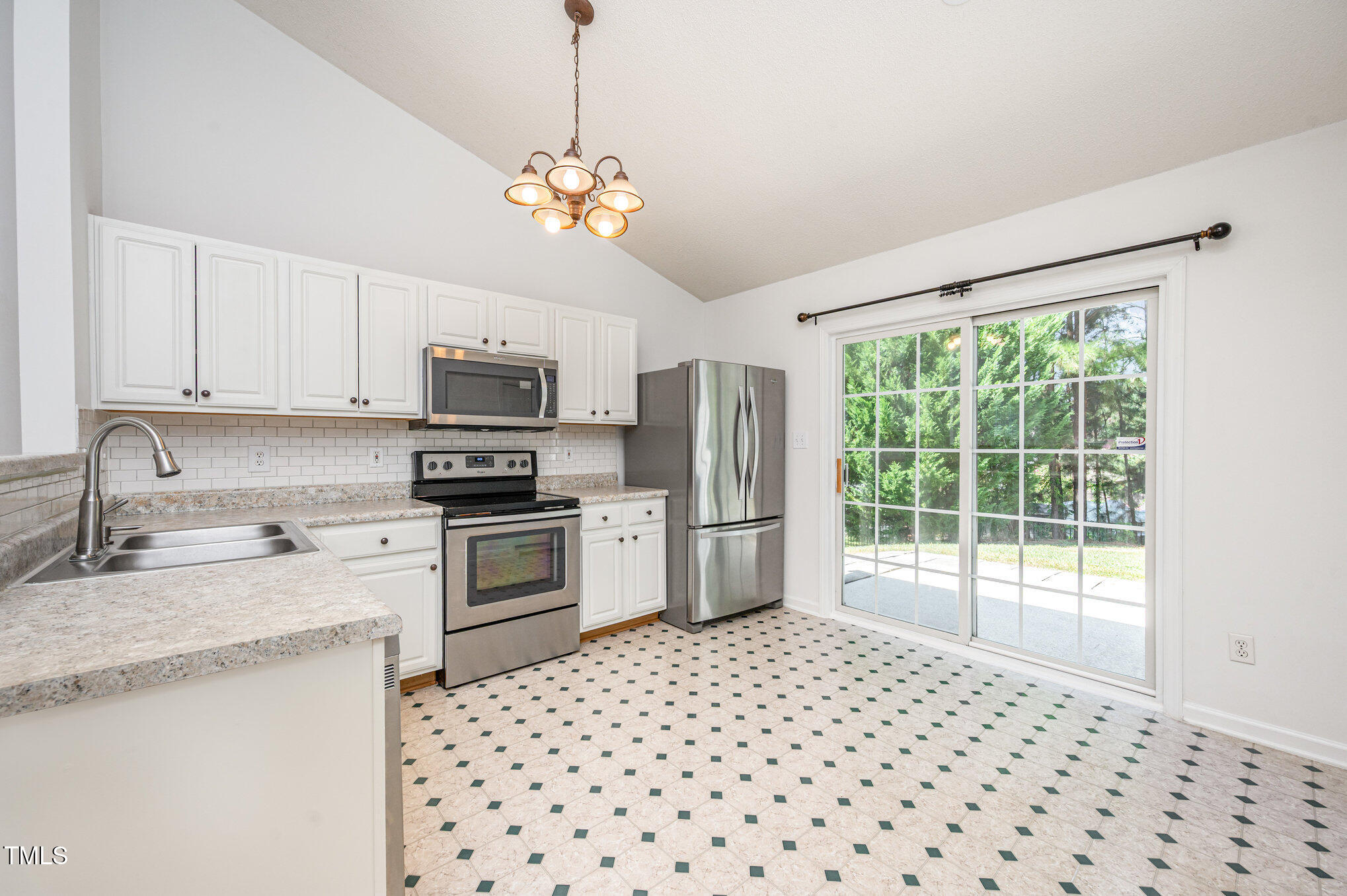 102 Checker Court Apex, NC 27502 - Photo 7 of 15 a kitchen with granite countertop a stove a sink dishwasher a refrigerator with white cabinets and wooden floor