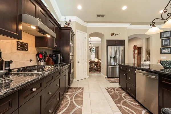 a kitchen with stainless steel appliances granite countertop a stove and cabinets