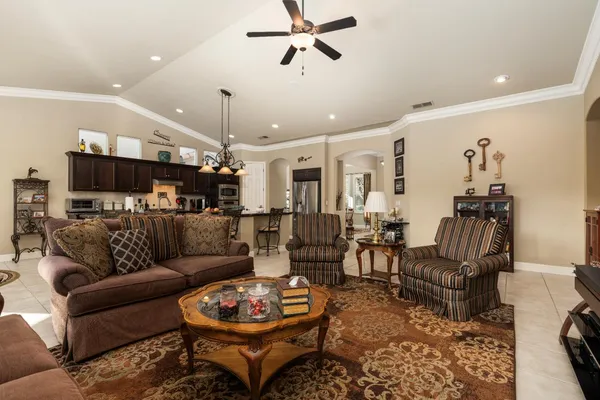 a living room with furniture and a view of kitchen