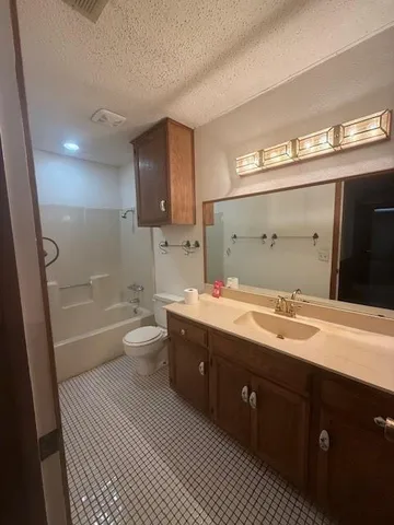 a spacious bathroom with a double vanity sink a toilet and a shower